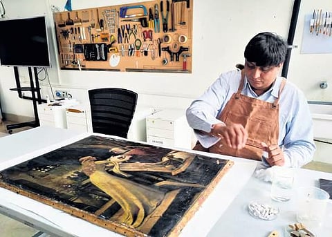 Achal Pandya restores an oil on canvas work (artist unknown) at the IGNCA Conservation Lab