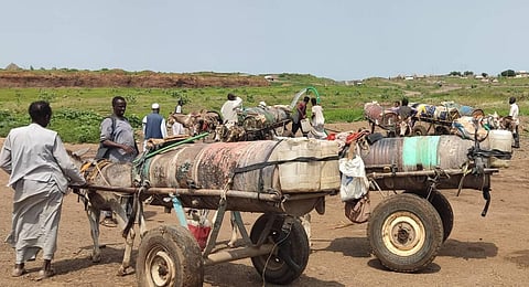 Men queue to fill tanks with water from an underground well in Gadaref city. (Photo | AFP)