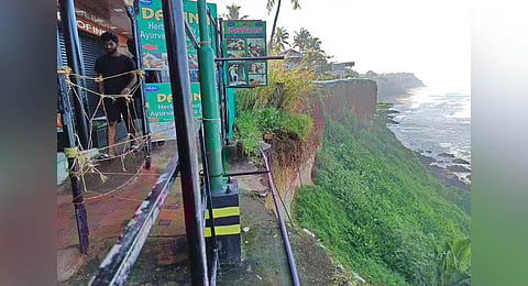 A temporary fence put up by traders to alert tourists. The dilapidated pathways have been posing a threat to tourists on the cliff in Varkala. (Photo | B P Deepu)