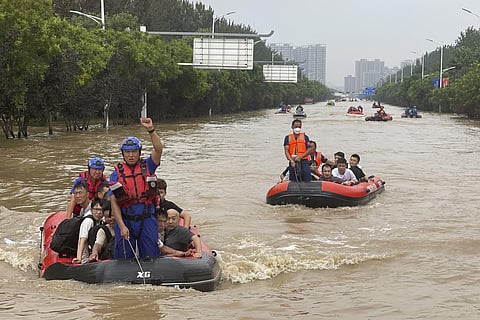Residents are evacuated by rubber boats through flood waters in Zhuozhou in northern China's Hebei province, south of Beijing. (Photo | AP)