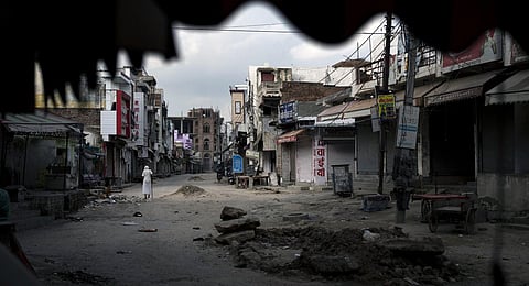 An elderly man walks in an area deserted after communal clashes in Haryana's Nuh, India, Tuesday, Aug 1, 2023. (Photo | AP)