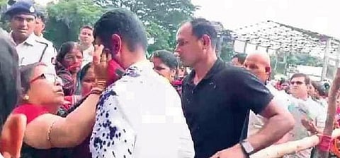 An elderly woman cleans up Pandian’s face after the ink attack at Sakhigopal