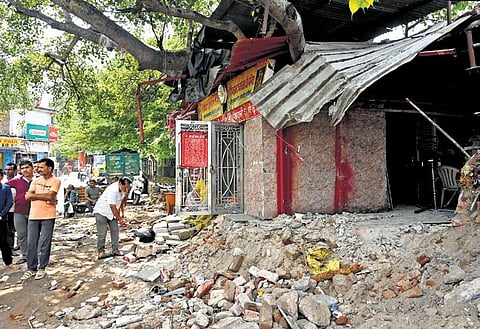 People gather near the Pipleshwar Dev Balaji Temple after a demolition drive was carried out to remove religious shrines on illegal land in New Delhi on Sunday. (Photo | Parveen Singh Negi, EPS)