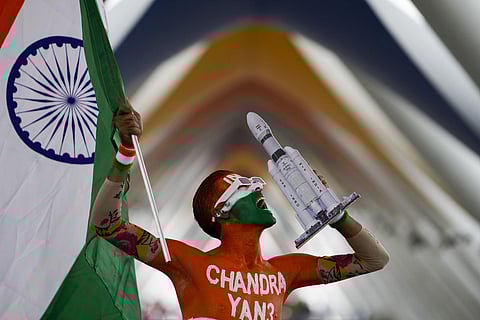 A man cheering for the successful landing of India’s moon craft Chandrayaan-3, on the moon surface, poses with the Indian flag in Ahmedabad. (Photo | AP)