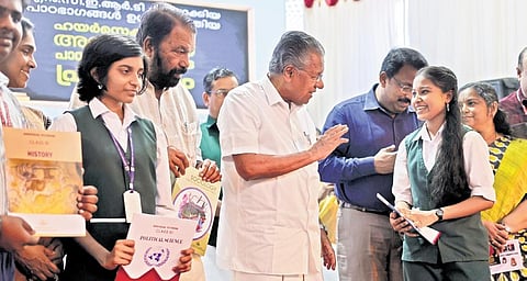 Chief Minister Pinarayi Vijayan chats with a student after releasing the additional Higher Secondary textbooks. (Photo | Express)