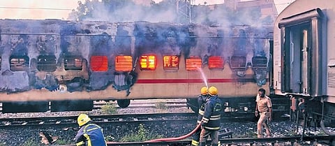 Fire and rescue service personnel trying to douse a fire in an IRCTC tourist coach at a railway yard near the Madurai Railway Junction at dawn on Saturday | Express
