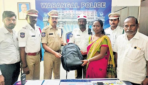 Warangal police officials return the bag containing jewellery to K Joshna on Sunday after auto driver Mohammad Fahimuddin (first from right) handed it over to cops