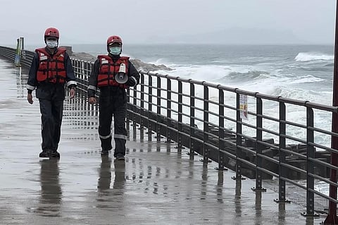 Coast guard officers patrol along the coast ahead of typhoon Khanun in the port city of Keelung near Taipei in northern Taiwan on Thursday, Aug. 3, 2023. (Photo | AP)