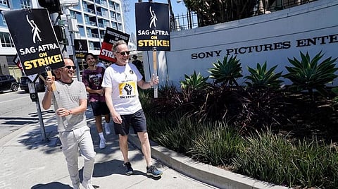 Aaron Paul and Bryan Cranston, cast members from the tv series 'Breaking Bad,' walk on a picket line outside Sony Pictures studios on Tuesday, Aug. 29, 2023, in Culver City, Calif. (Photo | AP)
