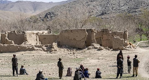 Children stand in front of a home destroyed. (Photo | AP)