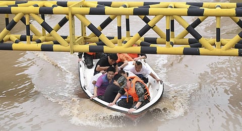 In this photo released by Xinhua News Agency residents are evacuated from flooded areas in Zhuozhou in northern China's Hebei Province. (Photo | AP)