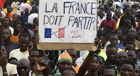Protesters hold an anti-France placard during a demonstration on independence day in Niamey. (Photo | AFP)