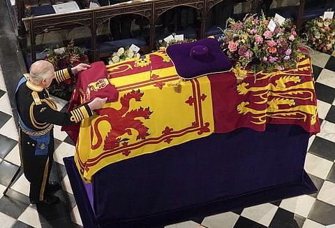 King Charles III places the Queen's Company Camp Colour of the Grenadier Guards on the coffin at the Committal Service for Queen Elizabeth II, held at St George's Chapel in Windsor Castle. (Photo | AP