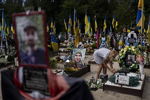 Natalie Zaichenko, 60, tends to the grave of her son, a Ukrainian soldier who was killed in the war against Russia, in Kyiv, Ukraine.