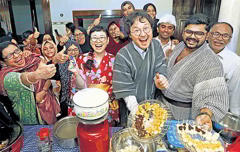Japanese volunteers to Kerala and natives of Kuttichira in Kozhikode sharing their respective cuisines as part of a cultural exchange programme on Friday. (Photo | Express)