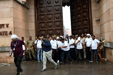ASI officials come out amid rainfall after the completion of the scientific survey work at the Gyanvapi mosque in Varanasi, on August 5, 2023. (PTI)