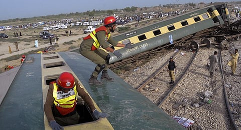 Rescue workers look survivors at the site of a passenger train derailed near Nawabshah, Pakistan, Sunday. (Photo | PTI)