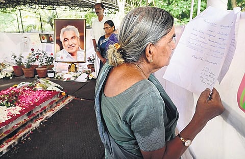 A visitor reads the intercessory prayer requests placed at the tomb of Oommen Chandy at St George Orthodox Church in Puthuppally on Monday | Vishnu Prathap