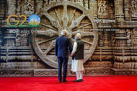 PM Narendra Modi explains the history of the Konark Wheel, a replica of which is serving as the backdrop, to US President Joe Biden upon his arrival for the G20 Summit at the Bharat Mandapam | pti