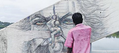 Saravanan draws on the arches of the Manappuram bridge in Aluva. (Photo | Express)