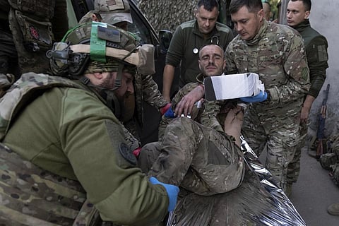 Ukrainian paramdedics from 3rd assault brigade move their wounded comrade on a stretcher arriving from the battlefield to the field hospital near Bakhmut, Ukraine, Sept 10, 2023. (Photo | AP)