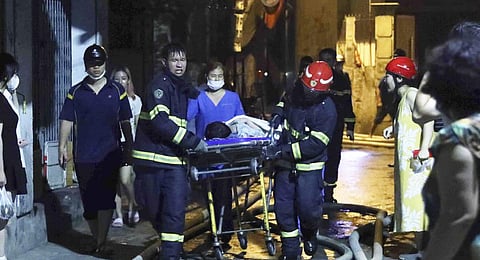 Rescue workers carry a person on stretcher out of a building on fire in Hanoi, Vietnam Wednesday, Sept. 13, 2023. (Photo | AP)