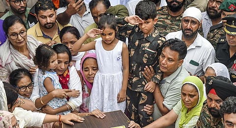 Colonel Manpreet Singh's children salutes as family members and relatives mourn near his mortal remains before his last rites, at his native place in Mohali.(Photo |PTI)