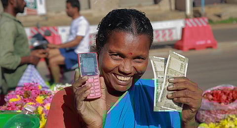 Rani, a widow who sells flowers, poses after receiving Rs. 1000 under Kalaignar Scheme for Right of Women. (Photo | PTI)