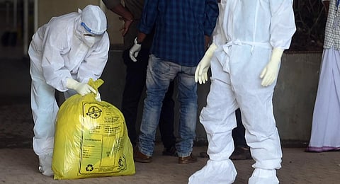 A health worker at Kozhikode Medical College Hospital awaiting vehicle to dispose of waste from Nipah isolation ward | E Gokul