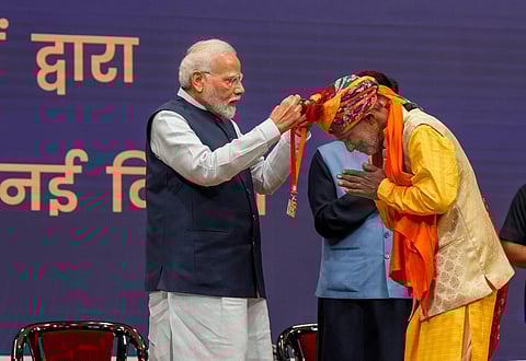 Prime Minister Narendra Modi with a 'Vishwakarma' during the launch of 'PM Vishwakarma' scheme at India International Convention and Expo Centre (IICC), in New Delhi, on Sept. 17, 2023. (PTI)