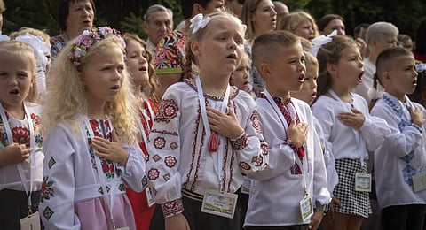 Schoolgirls sing Ukraine's national anthem as they attend a ceremony of the first day in school in Bucha, Ukraine. (Photo | AP)