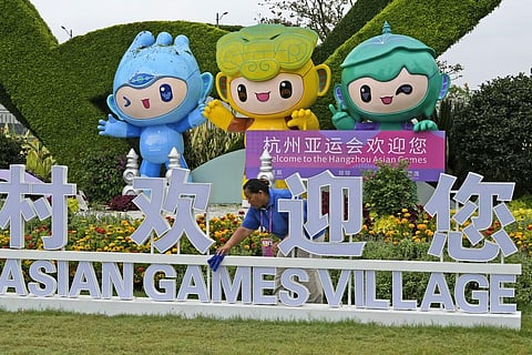 A staff member cleans an Asian Games sign ahead of the 19th Asian Games in Hangzhou, China, Thursday, Sept. 21, 2023. (Photo | AP)