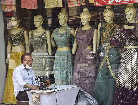 FILE: A tailor waits for customers outside a shop at Kamala Nagar market. (Photo | PTI)