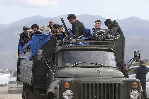 Ethnic Armenians from Nagorno-Karabakh ride a truck on their way to Kornidzor in Syunik region, Armenia, Sept. 26, 2023. (Photo | AP)