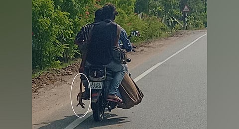 A youth carries a Bengal Monitor lizard (Udumu) on a bike in Karimnagar district. (Photo | Express)