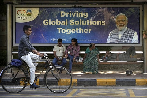 A cyclist rides past a bus waiting shelter with a poster of PMÂ Narendra Modi ahead of this week's summit of the Group of 20 nations in New Delhi, India, Monday, Sept. 4, 2023. (Photo | AP)