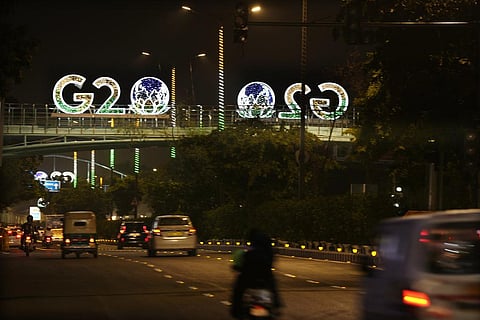 FILE - G20 logos are illuminated with the colors of the Indian flag on a pedestrian bridge in New Delhi. (Photo | AP)