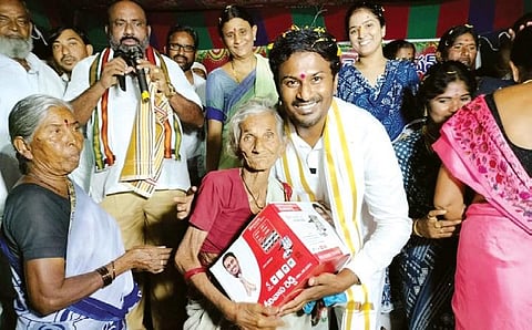 Congress ticket Kandi Srinivas Reddy gifts pressure cookers to women on Friday. (Photo | Express)