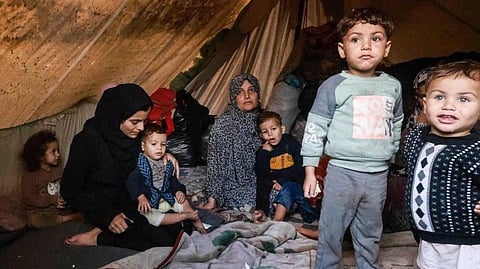 Palestinians rest in their makeshift tent at a camp set up on a schoolyard in Rafah in the southern Gaza Strip where most civilians have taken refuge.