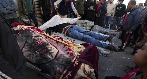Palestinians stand around people killed after an Israeli strike hit a building next to the Al-Aqsa Hospital in Deir al Balah, Gaza Strip. (Photo | AP)