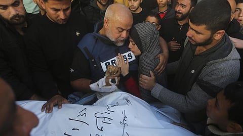 Al Jazeera journalist Wael Dahdouh holds the hand of his son Hamza, who also worked for Al Jazeera and was killed in an Israeli airstrike in Rafah, Gaza Strip, Sunday, Jan. 7, 2024.