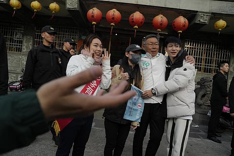 Ko Wen-je, Taiwan People's Party (TPP) presidential candidate, take photos with young supporters outside a temple in New Taipei City, Taiwan on Wednesday. (Photo | AP)