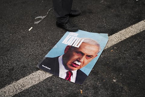 A man stands over a photograph of Israeli PM Benjamin Netanyahu that reads in Turkish: 'Baby killer' during a pro-Palestinain protest in Istanbul, Monday, Jan. 1, 2024. (File Photo | AP)