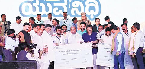 CM Siddaramaiah hands over stipend cheques to beneficiaries of the Yuva Nidhi scheme in Shivamogga on Friday | Express