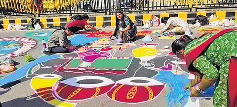 Artists participating in Rangoli Mahotsav themed on Dhanuyatra in front of Women’s College to Gourpada in Bargarh Town. (Photo | Express)