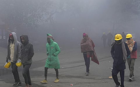 Labourers walk through fog on a cold winter morning, in New Delhi, Sunday, Jan. 14. (Photo | PTI)