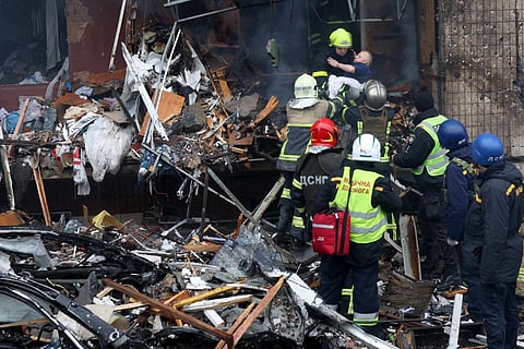 Firefighters evacuate a disabled person from a destroyed multi-storey building after a missile attack in the centre of Kyiv, on January 2, 2024. (Photo | AFP)