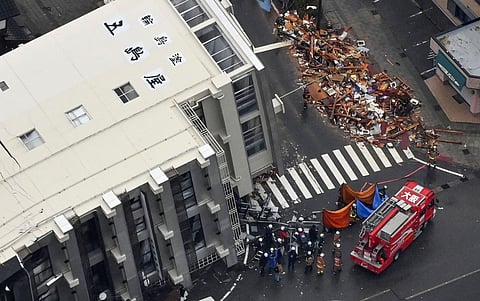 Firefighters gather around a fallen building hit by earthquakes in Wajima, Ishikawa prefecture, Japan. (Photo| AP)