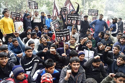 Young wrestlers hold placards during a protest against wrestlers Sakshi Malik, Bajrang Punia and Vinesh Phogat at Jantar Mantar, in New Delhi. (Photo | Parveen Negi)