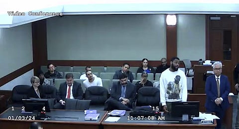 Defendant Deobra Redden in a white long-sleeved shirt is seen standing next to his defense attorney at his sentencing in a felony battery case. (Photo | AP)